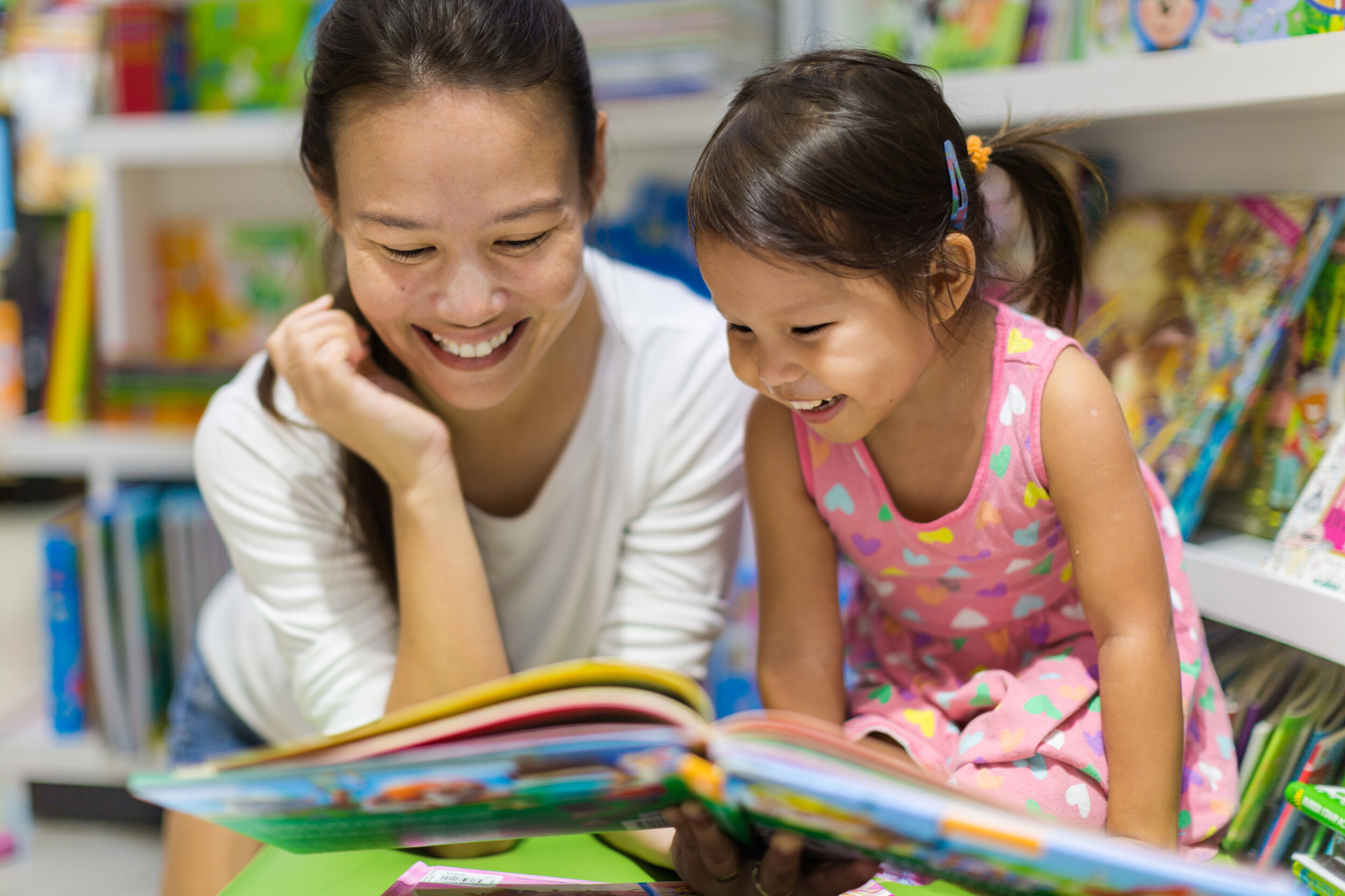 Mother and daughter reading together from educational consultant reading guidance